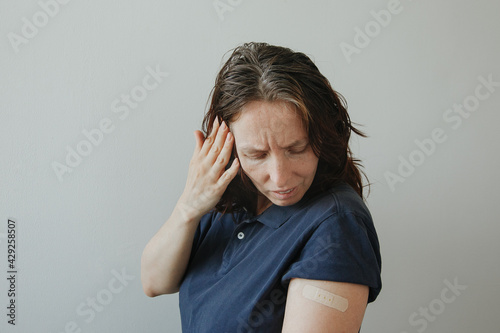 woman having headache after covid-19 vaccination