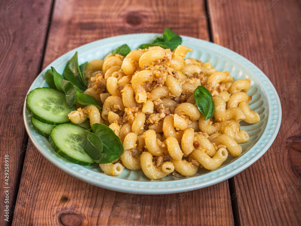 Breakfast with minced chicken pasta and basil leaves on a ceramic salad plate Breakfast with minced chicken pasta and basil leaves on a ceramic salad plate