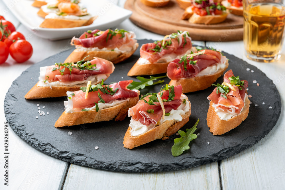 Crostini con prosciutto crudo e formaggio, antipasti italiani Crostini con prosciutto crudo e formaggio, antipasti italiani
