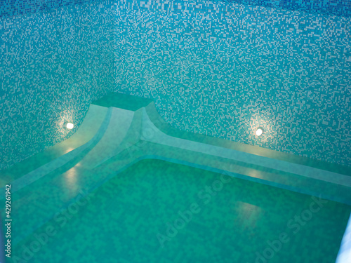 the pool is lined with blue tiles. indoor swimming pool is covered. rest in a sanatorium in a spa