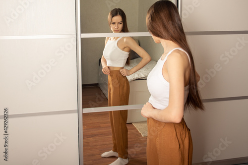 Foto Teen anorexia, bulemia, skinny teen girl looks in the mirror and sees herself fa