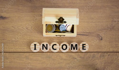 Income symbol. Concept word income on wooden cubes on a beautiful wooden background, small wooden chest with coins. Business and income concept.