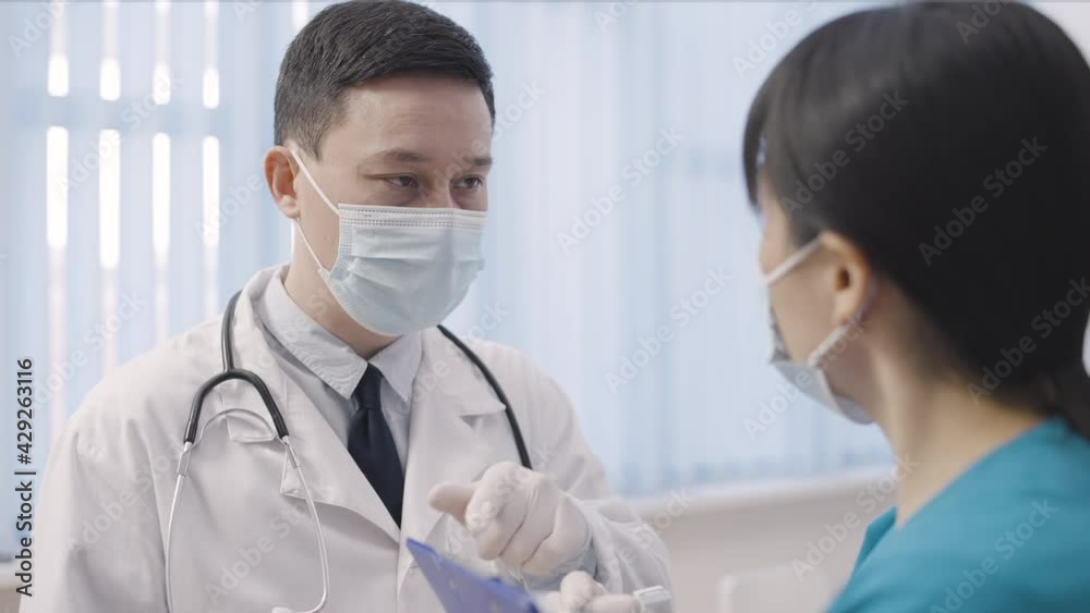 Male therapist instructing female nurse on prescription for patient, teamwork Male therapist instructing female nurse on prescription for patient, teamwork