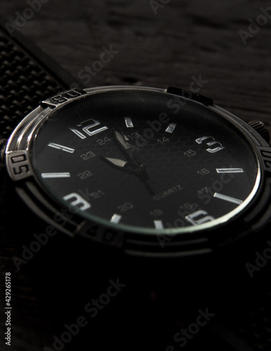  details of elegant silver watch with black wood background