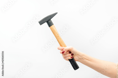 Female hand with red manicure holds hammer isolated on white background.