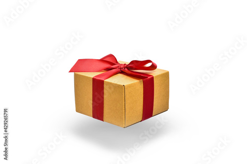 Fototapeta Naklejka Na Ścianę i Meble -  flying box with a red ribbon on a white background with a shadow.  present in beige packaging.  presentation of the gift. 