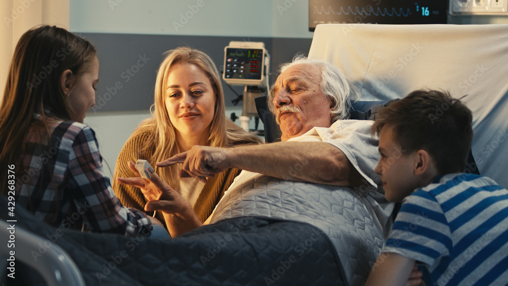 Senior patient speaking with daughter and grandchildren in hospital Senior patient speaking with daughter and grandchildren in hospital
