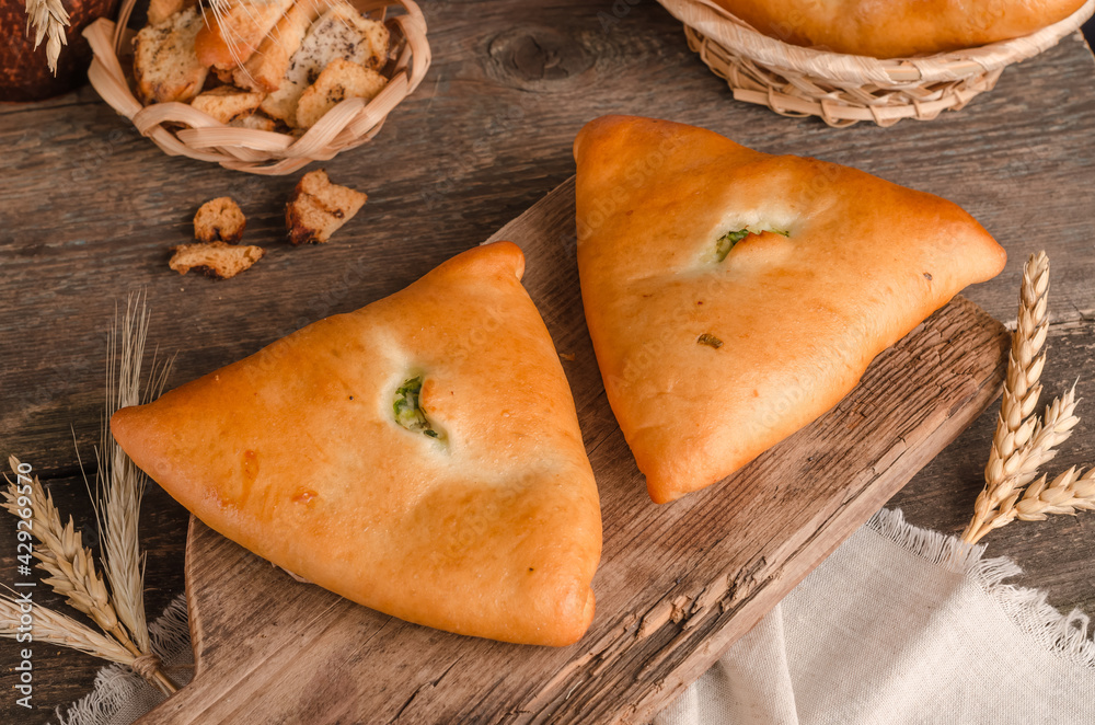 Appetizing fresh culinary pastry - pies with different fillings on a wooden Appetizing fresh culinary pastry - pies with different fillings on a wooden