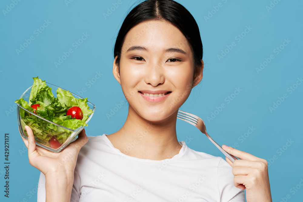 woman with salad in a plate and iron fork model asian appearance woman with salad in a plate and iron fork model asian appearance