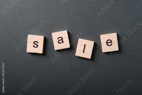 Sale word made from wooden cubes on dark background