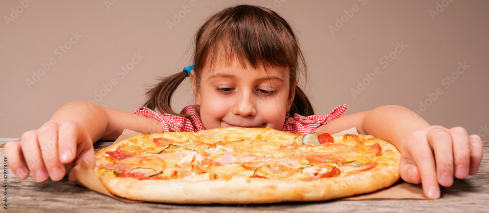 Very happy young beautiful girl enjoys pizza. Horizontal image.