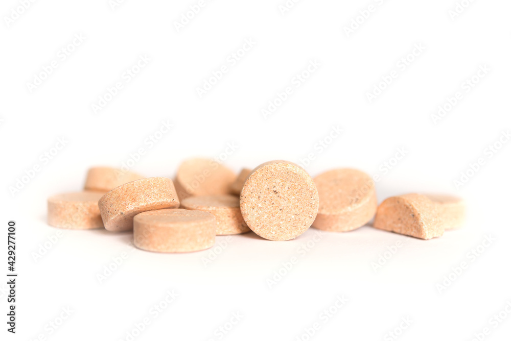 Colored pills on a white background. Round herbal tablets close-up. Healthcare and medicine. Colored pills on a white background. Round herbal tablets close-up. Healthcare and medicine.