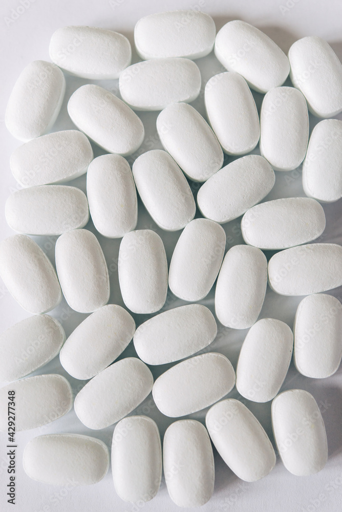 White pills on a white background. Oval white pills close up. Healthcare and medicine.
White pills on a white background. Oval white pills close up. Healthcare and medicine.