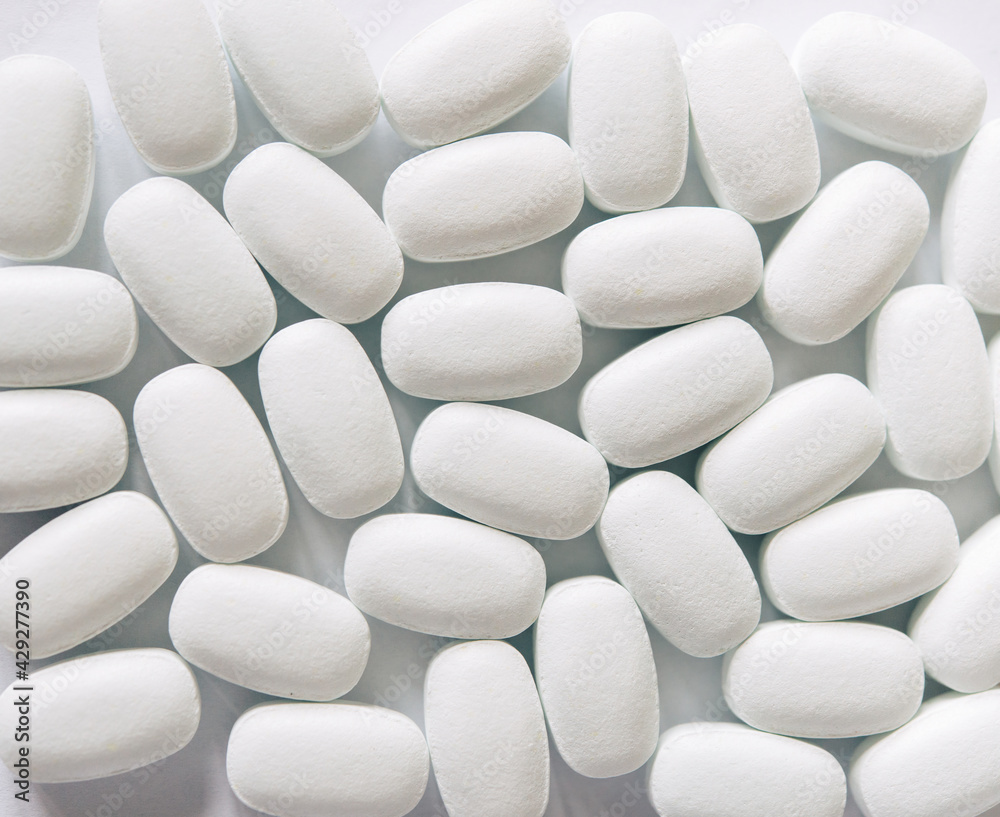 White pills on a white background. Oval white pills close up. Healthcare and medicine.
White pills on a white background. Oval white pills close up. Healthcare and medicine.