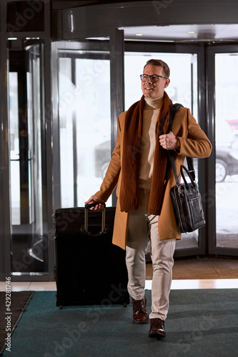Young excited caucasian business male entering lobby of hotel