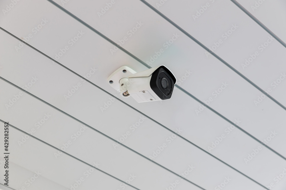 Online Security CCTV camera surveillance system outdoor of house. A blurred night city scape background. Real time Modern CCTV camera on a wall. Equipment system service for safety life or asset. Online Security CCTV camera surveillance system outdoor of house. A blurred night city scape background. Real time Modern CCTV camera on a wall. Equipment system service for safety life or asset.