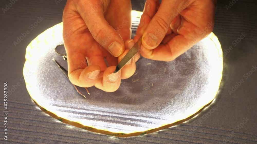 Adult man manicure with clipper and steel nail file. Cutting nails with nail clipper. Hands are resting on blue towel. Slow motion