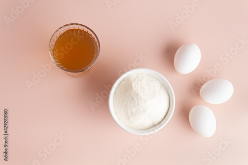 collagen and bone broth, eggs on a pink background