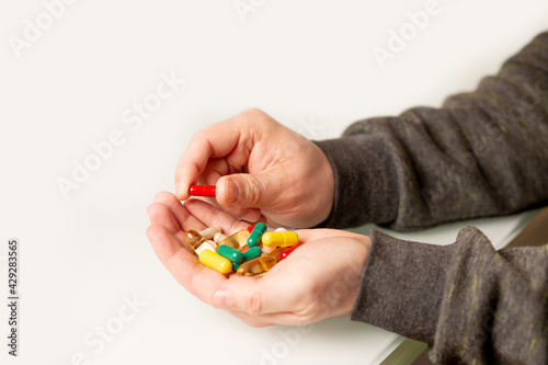 Man holding pile of vitamins and healthy supplement. Space for text
