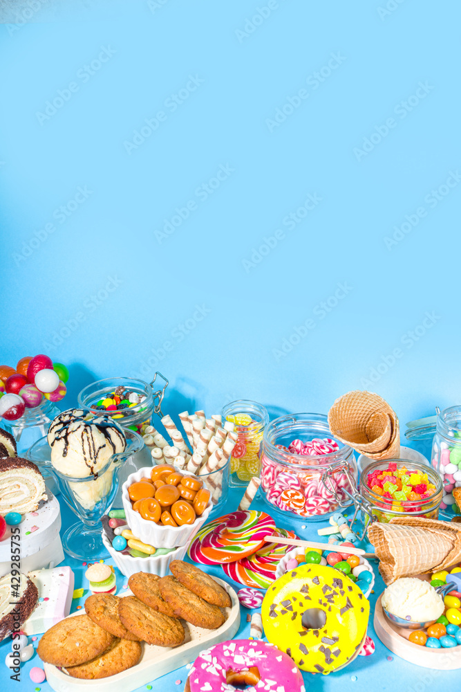 Selection of colorful sweets. Set of various candies, chocolates, donuts, cookies, lollipops, ice cream top view on trendy bright blue sunny background