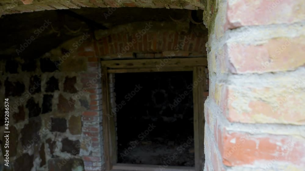 The red brick wall of the abandoned house with the small window on it The red brick wall of the abandoned house with the small window on it