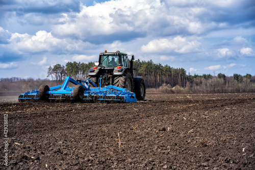 tillage in early spring. Tractor with aggregate