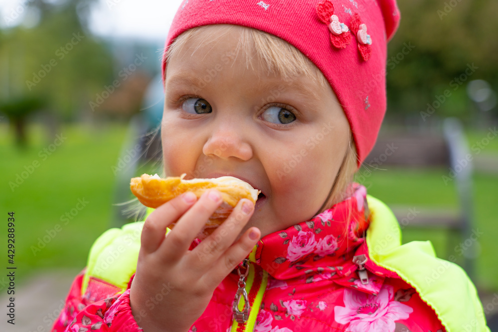 Girl eating cake in the park in spring Girl eating cake in the park in spring