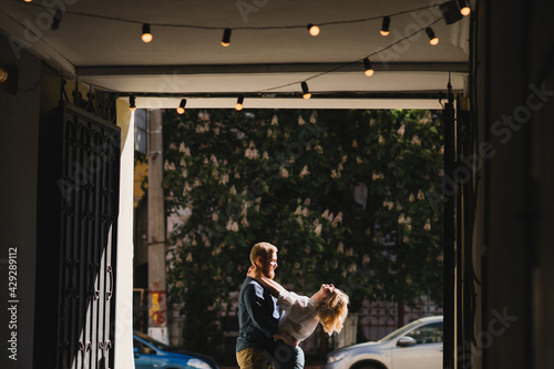 Romantic and happy caucasian couple in casual clothes walking together through the city streets. Love, relationships, romance, happiness concept. Man and woman holding hands and smiling.