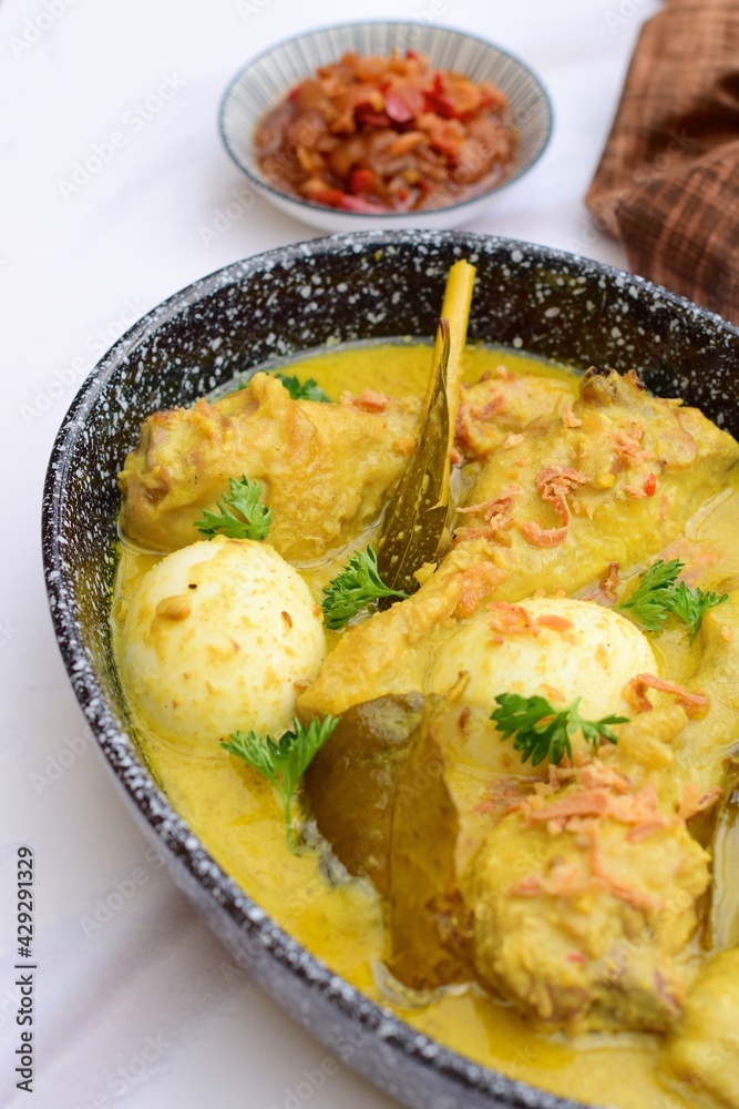 Opor ayam, chicken cooked in coconut milk from Indonesia, from Central Java, served with lontong and sambal. Popular dish for lebaran or Eid al-Fitr Opor ayam, chicken cooked in coconut milk from Indonesia, from Central Java, served with lontong and sambal. Popular dish for lebaran or Eid al-Fitr