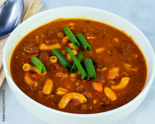a bowl of chili macaroni with green onions