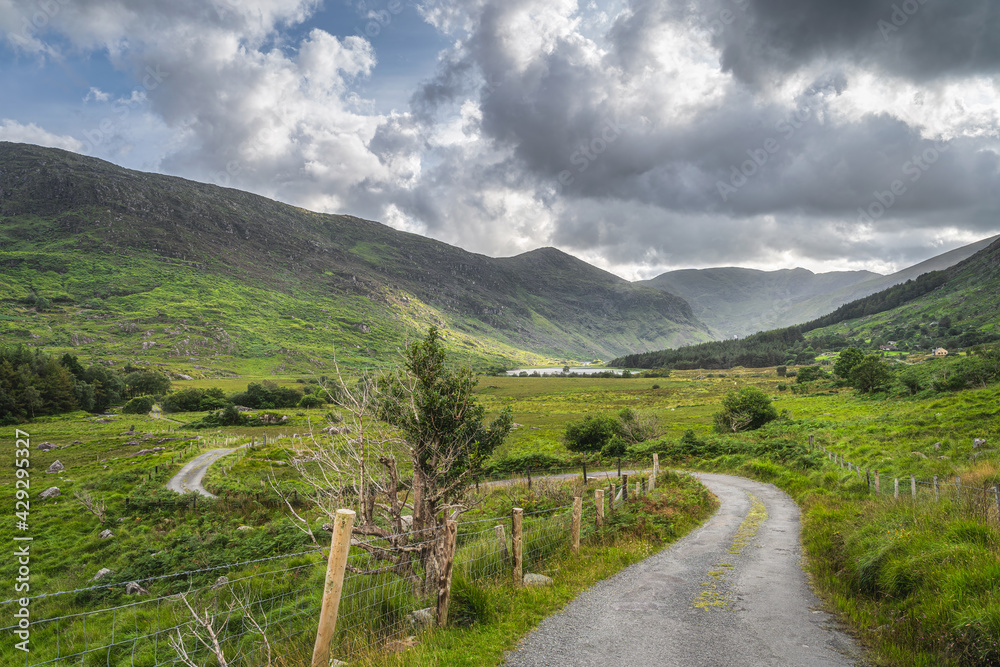 Φωτογραφία Winding country road leading trough Black Valley, rough landscape with lake and