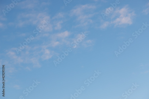Blue clear sky with light translucent white clouds.