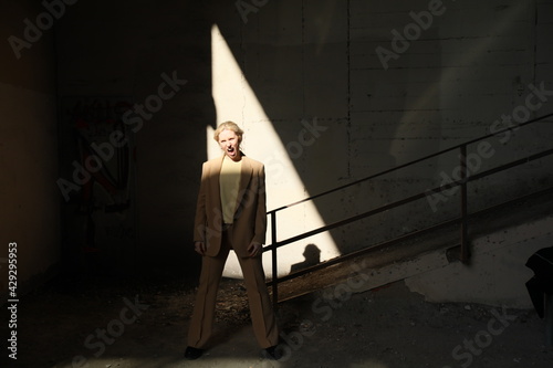 Portrait of beautiful young model wearing beige suit, posing outdoor.