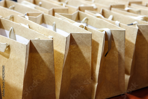 A lot of brown paper bags were lined up on the table. photo