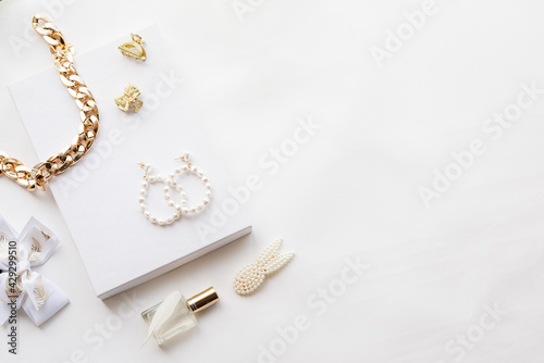 White and gold jewelry collection: chain, pearl earrings, hairpin, perfume. Jewelry for a woman. High quality photo