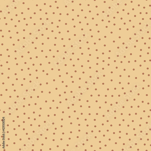 Polka dot fabric. An infinite number of brown dots on a beige background. Seamless coffee shade pattern for textiles, wrapping paper, pillows, bedding. Vector graphics.
