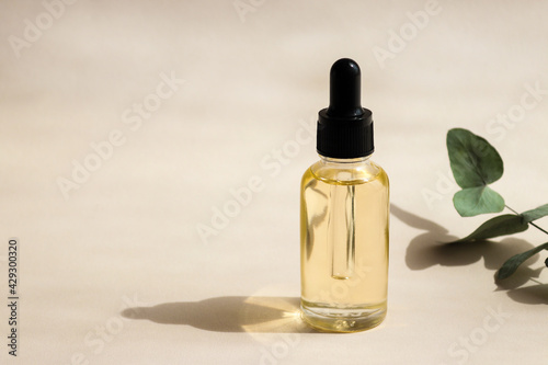 Bottle of cosmetic essential oil close-up with deep shadows. Selective focus. Beauty concept