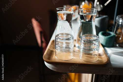 Four glass cups on the bar counter with serving accessories. © teksomolika