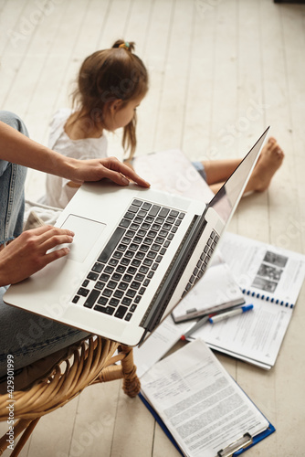 daughter watching mom work on computer