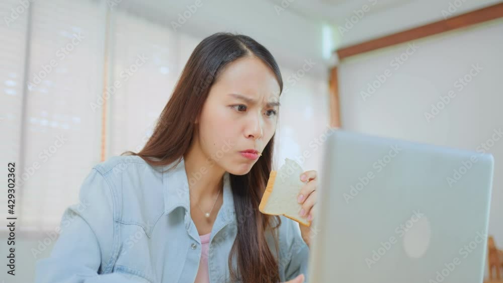 Asian beautiful girl feeling hungry while working on computer at home. Asian beautiful girl feeling hungry while working on computer at home.