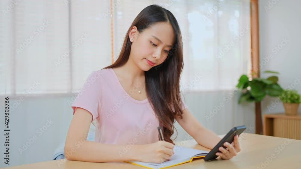Asian girl doing personal accounting by writing income and expenses. Asian girl doing personal accounting by writing income and expenses.