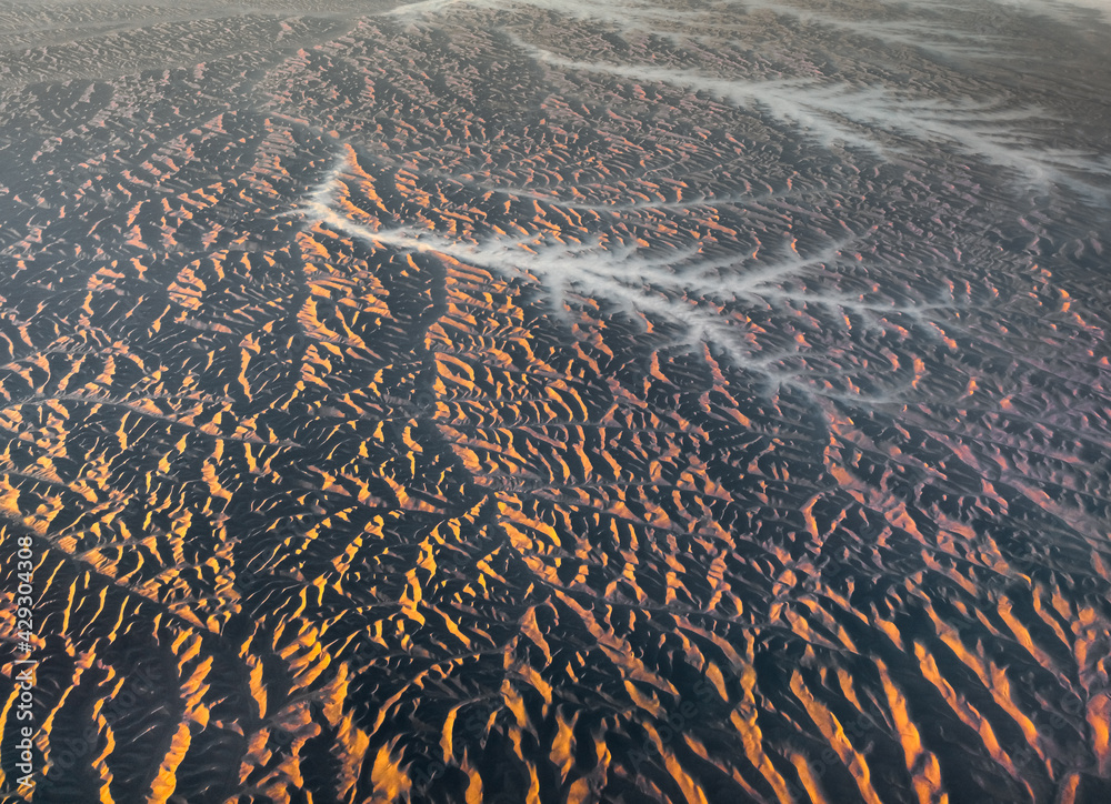 Aerial View from an Airplane. Flying above Beautiful Land at Sunrise.