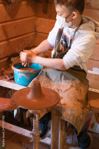 The boy is studying pottery. Clay modeling master class. Carpathians. Ukraine. photo