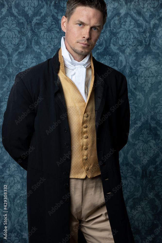 A handsome Regency gentleman wearing a gold waistcoat, breeches, and a ...