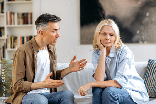Obraz na płótnie Emotional dialogue of a married couple in the living room on the couch