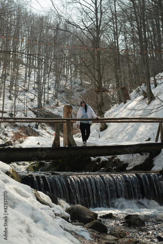 A woman with a child on a wooden bridge over a mountain river. Carpathians. Ukraine.