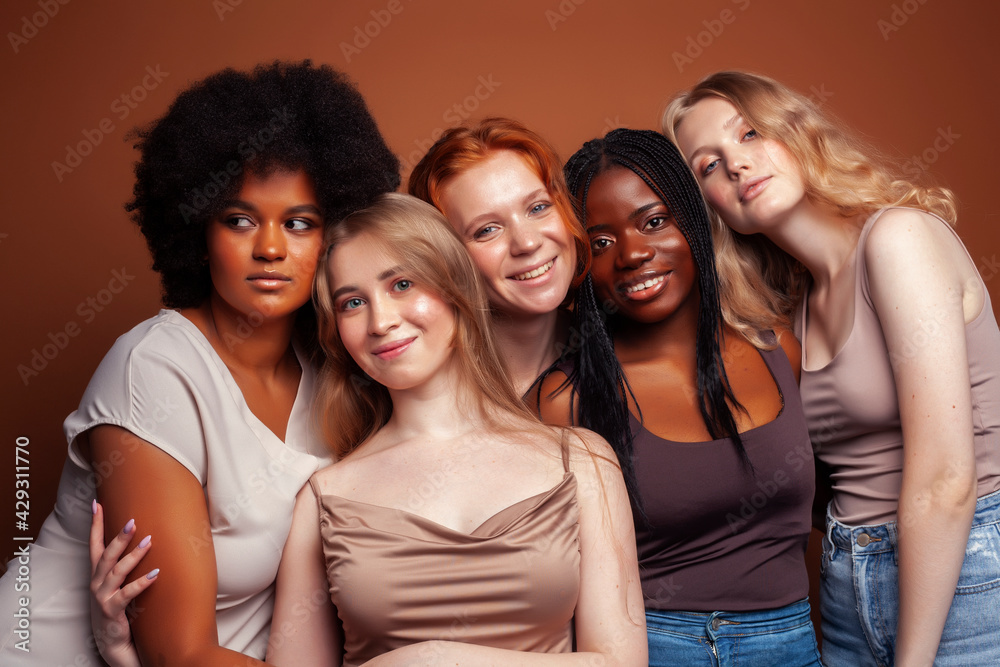 Obraz premium young pretty caucasian, afro, scandinavian woman posing cheerful together on brown background, lifestyle diverse nationality people concept
