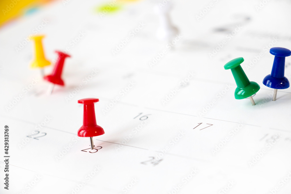 Pushpins on calendar, Background out of focus Pushpins on calendar, Background out of focus