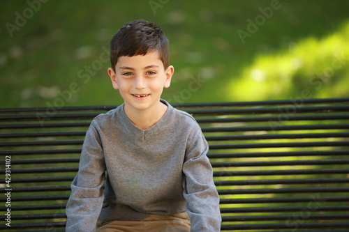 Little Boy Sitting on Park Bench