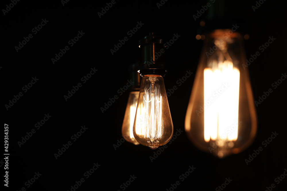 Edison light bulbs on black background, space for text Edison light bulbs on black background, space for text